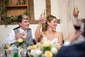 bride and groom cheers at their speeches on their wedding day