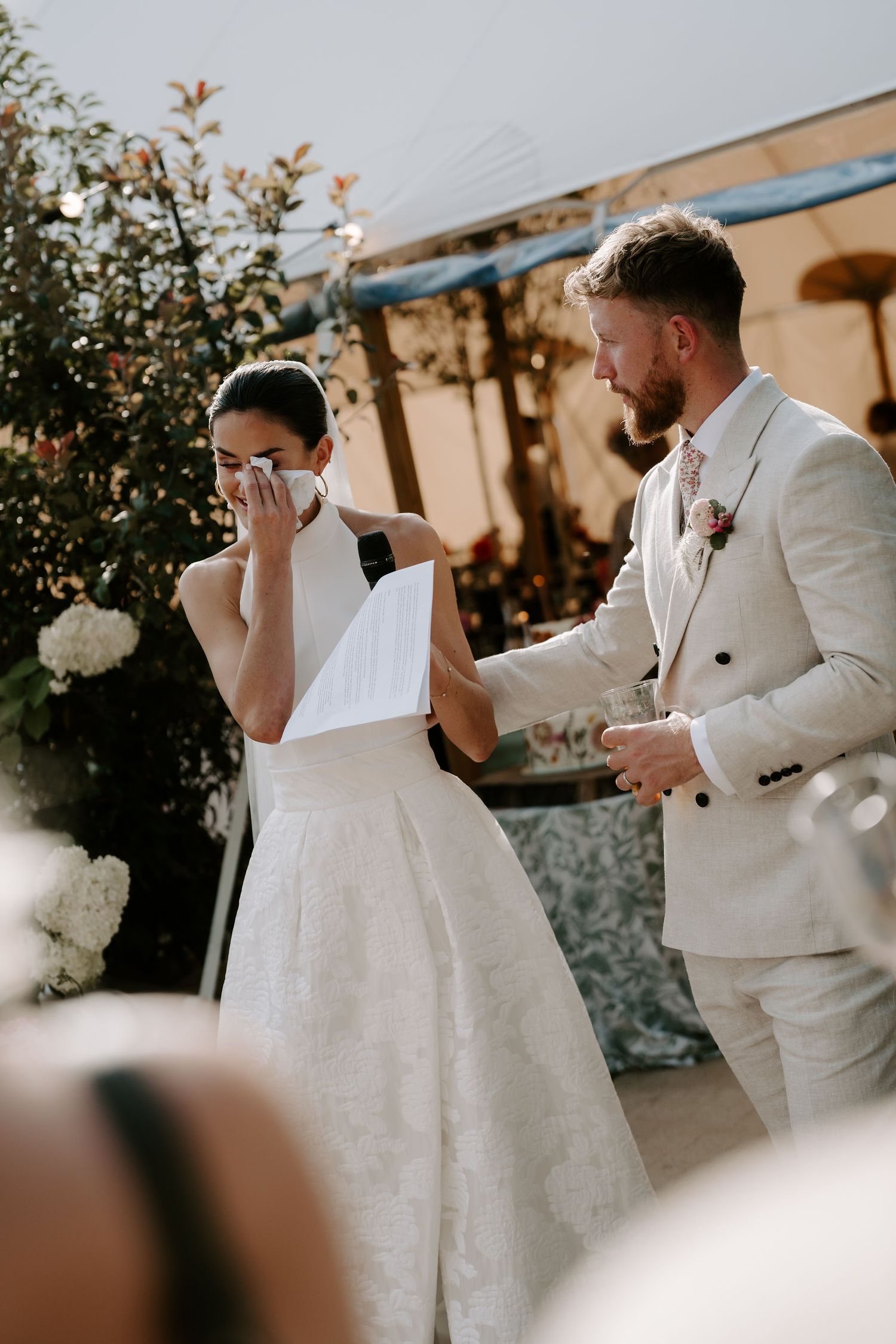 bride wiping her tears during her wedding speech at marquee wedding in islip in Oxfordshire