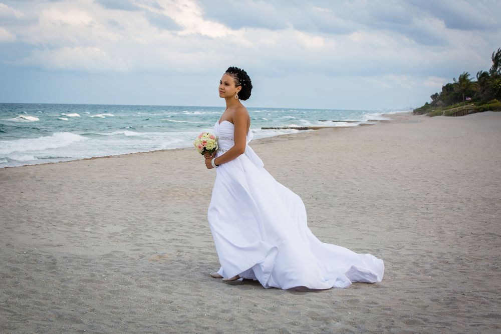 Romantic beach bridal photos with white dress flowing in the ocean breeze.