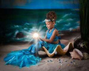 Fantasy-styled portrait session with starfish props and ethereal lighting effects.