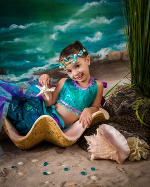 Whimsical mermaid-themed photo shoot with seashells and aqua accessories.
