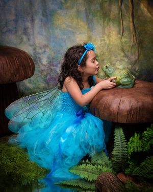 Whimsical fairy tale photo series featuring bright blue tulle dress and fantasy woodland setting.