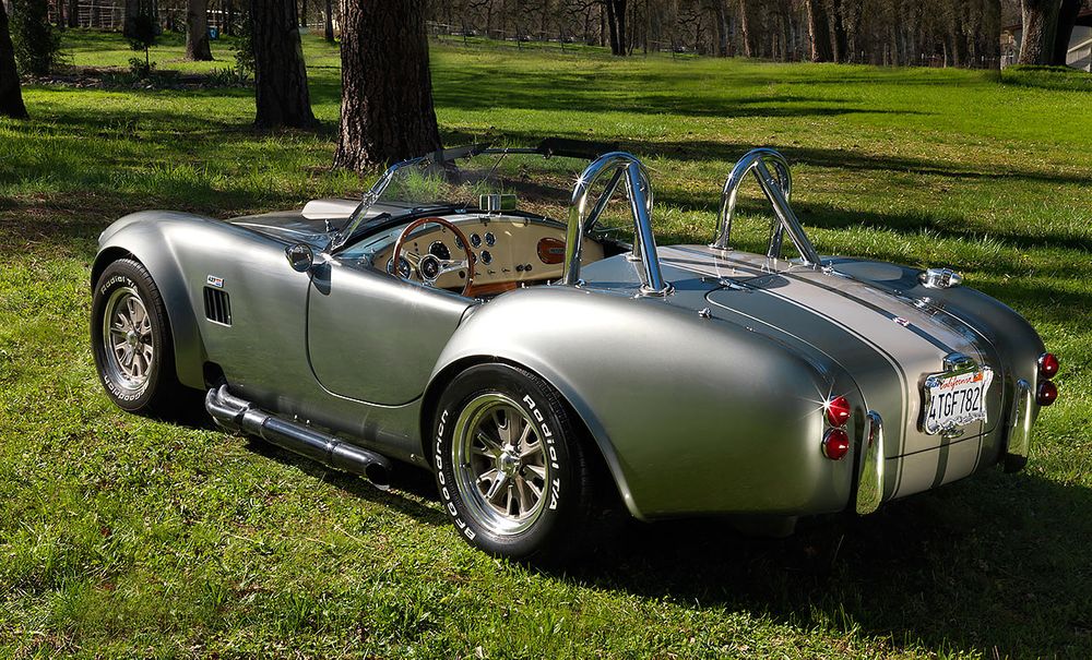 silver cobra sports car parked on a green lawn