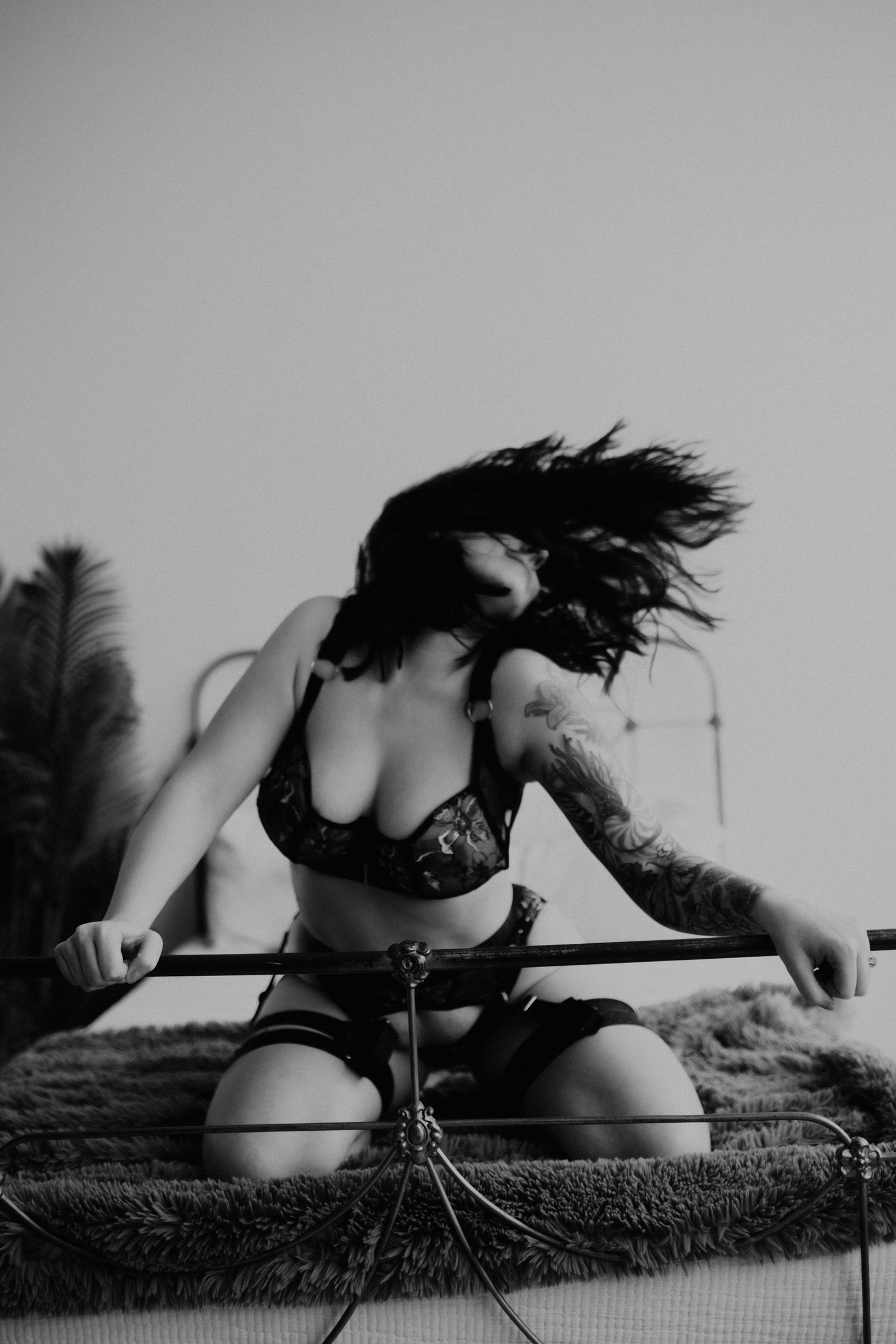 Urban boudoir photoshoot, woman flinging hair.