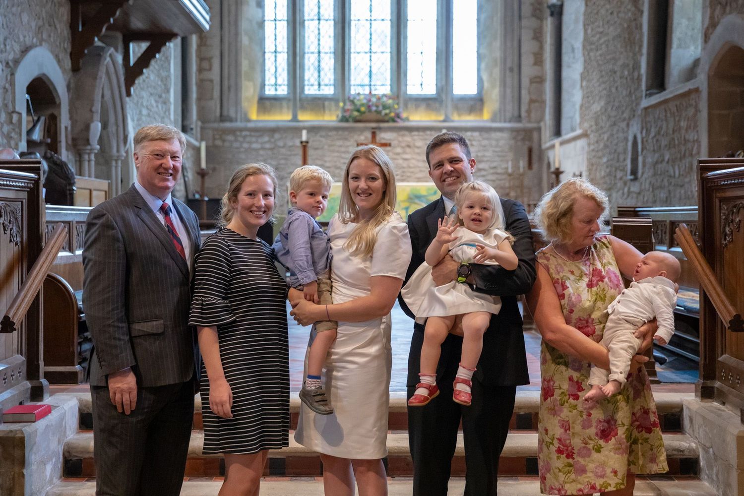 Family gathering inside a historic church with gothic architecture and stained glass windows.