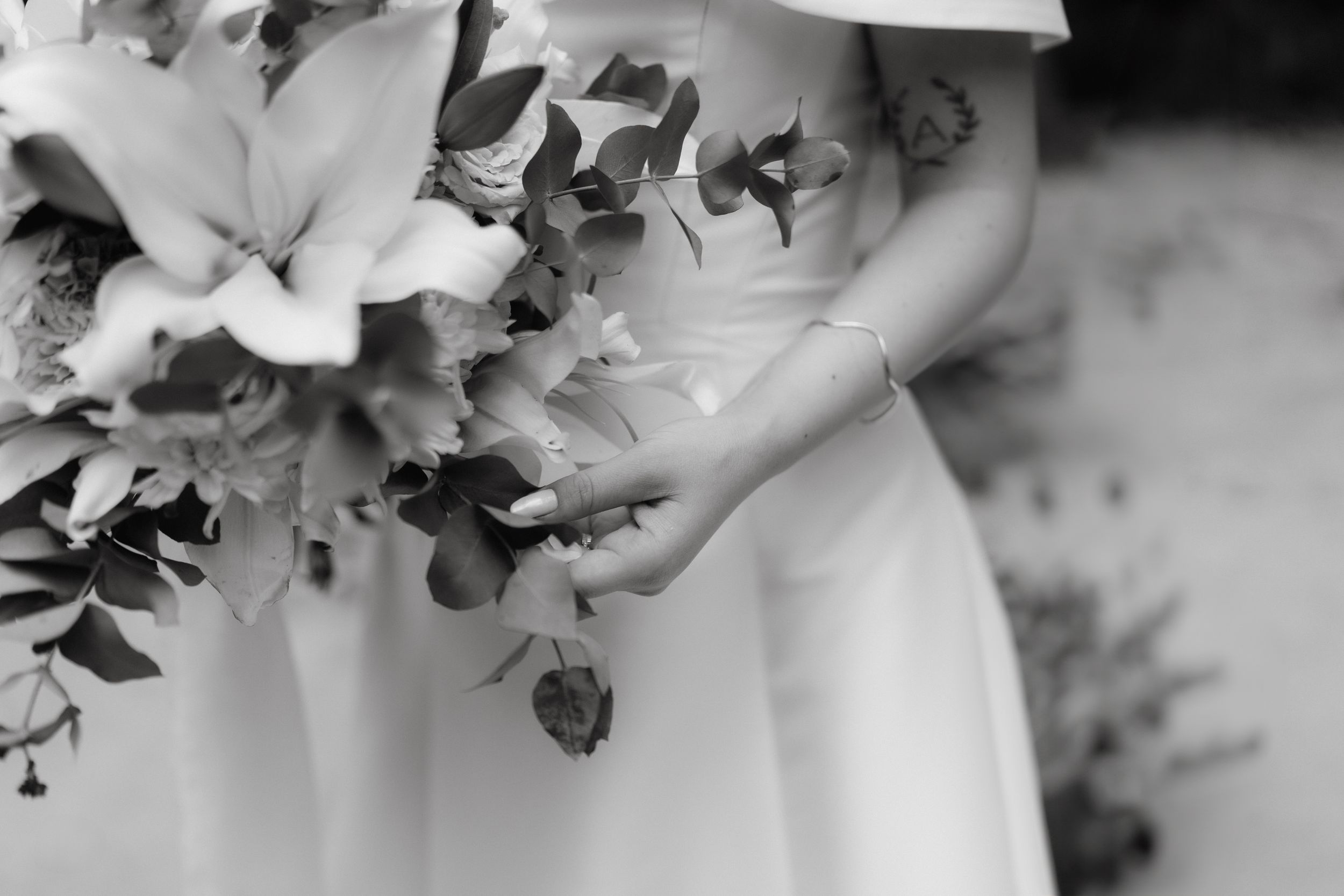 Delicate white floral arrangements decorating outdoor wedding venue.