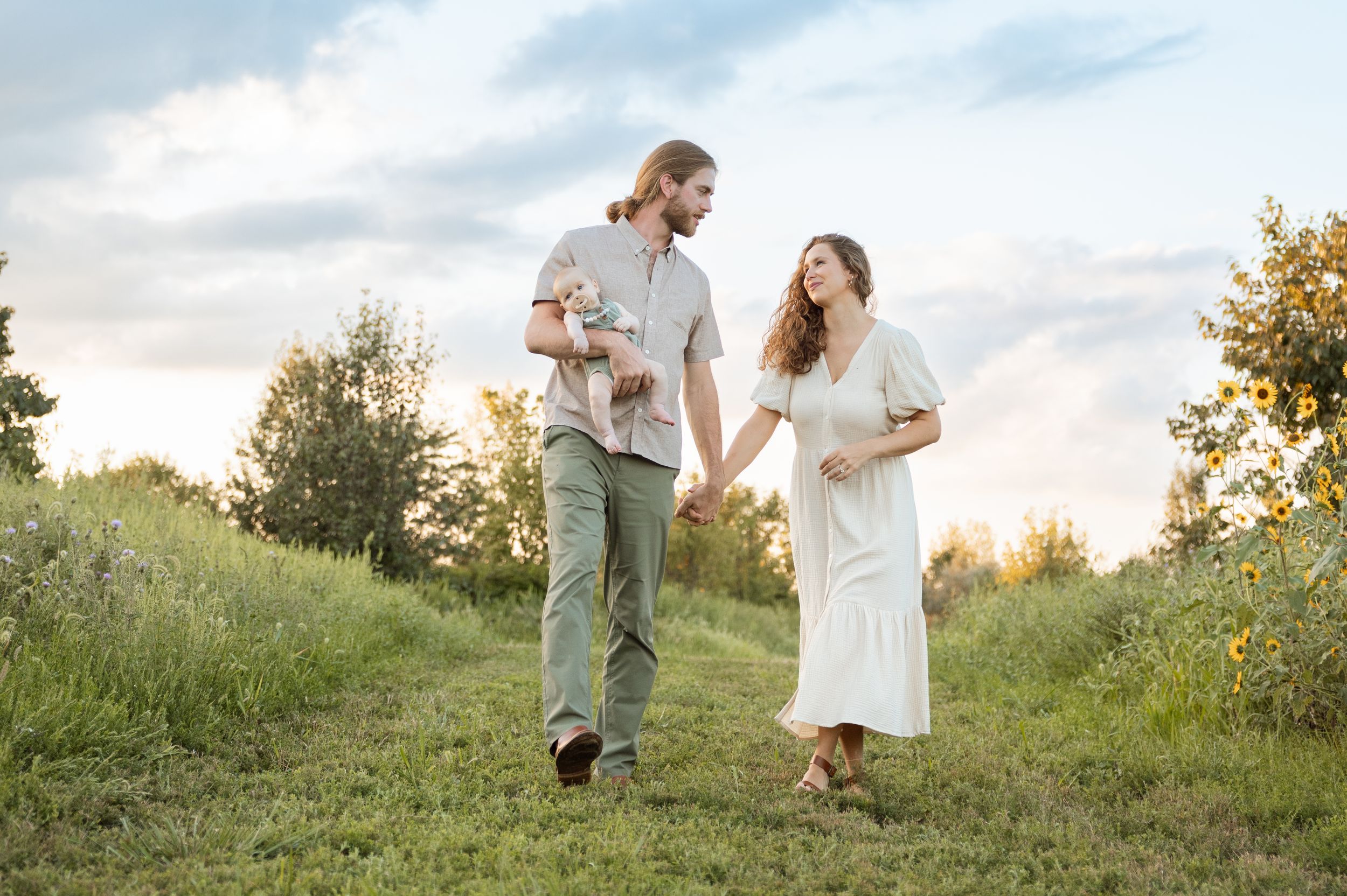 Southern Indiana couple with newborn walking in fields