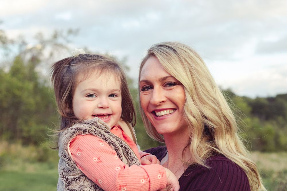 Mom and child in a green field with trees in South Hills, PA on a fall day portrait by Abby Gleason Photography