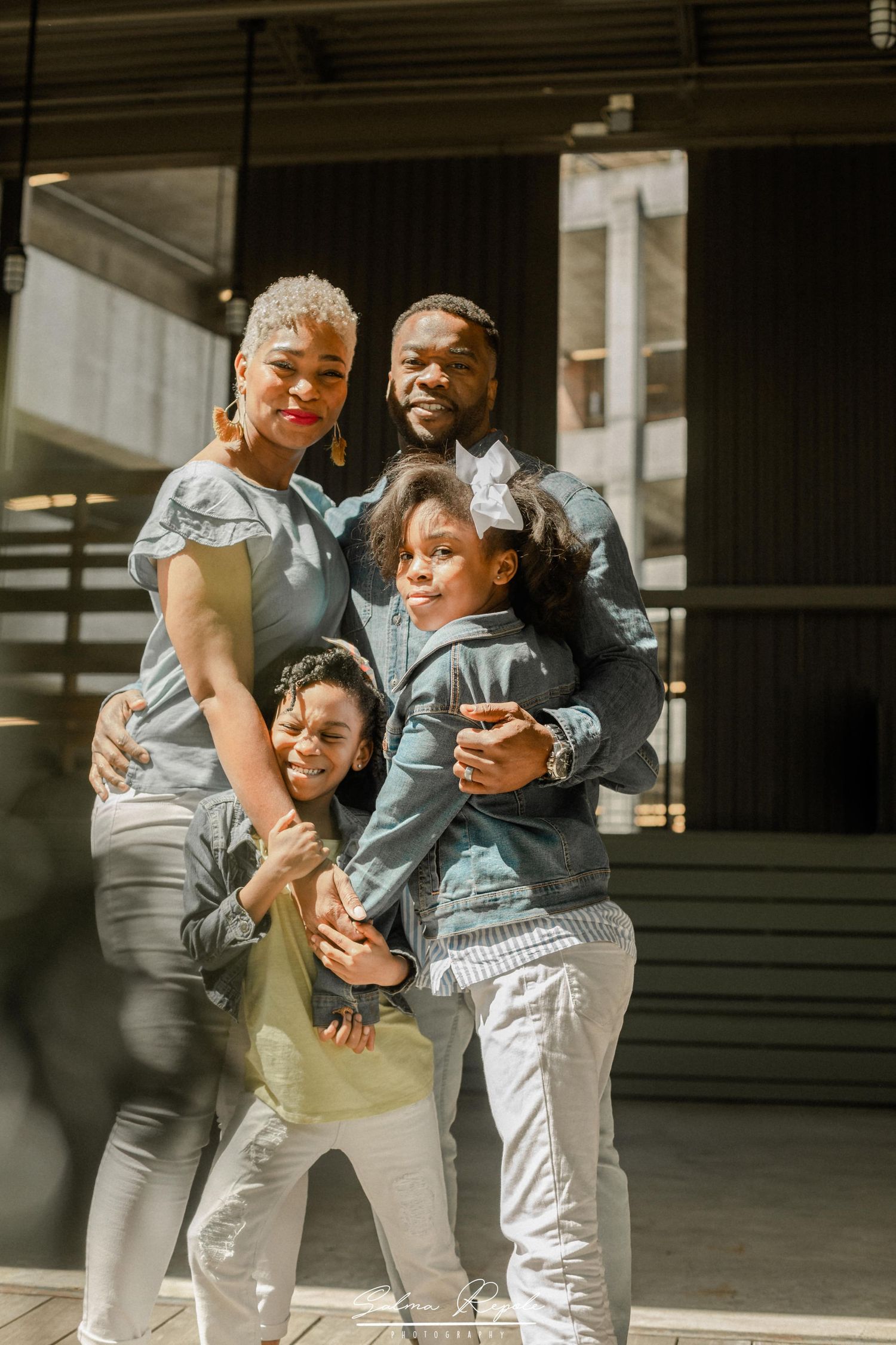 Family in matching gray outfits share candid moments and laughter together.