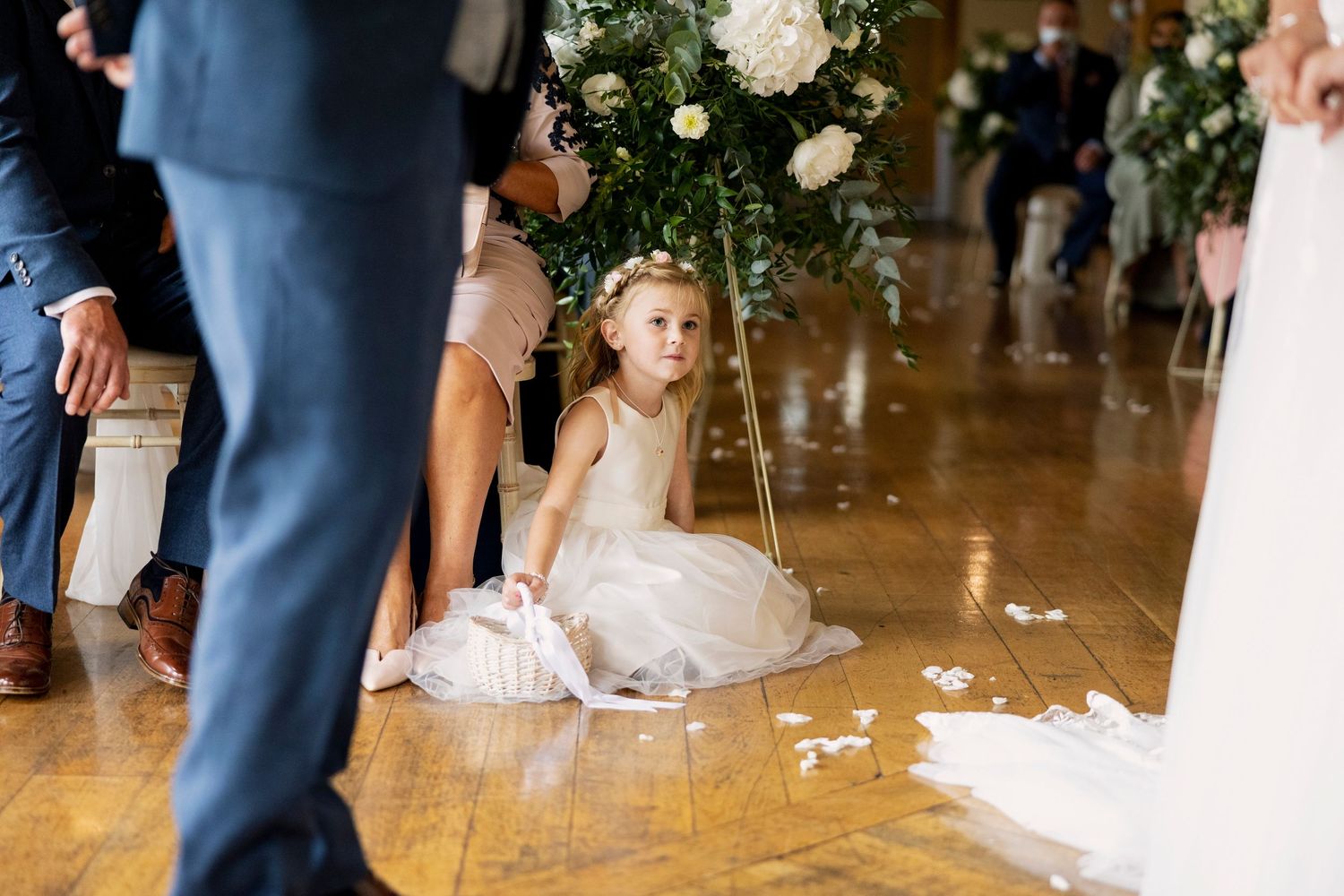 flower girl sitting on the floor during the wedding service Canada Lodge