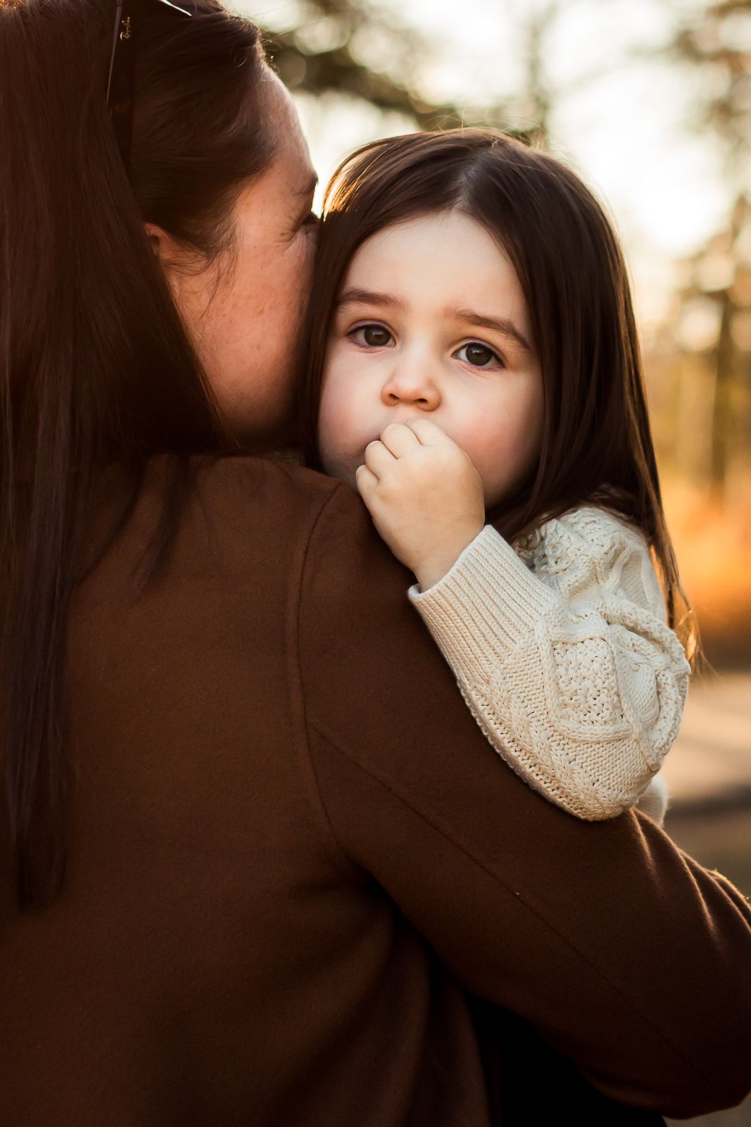 Beautiful mother daughter embrace during golden hour fall family photos at Glenmore Reservoir.