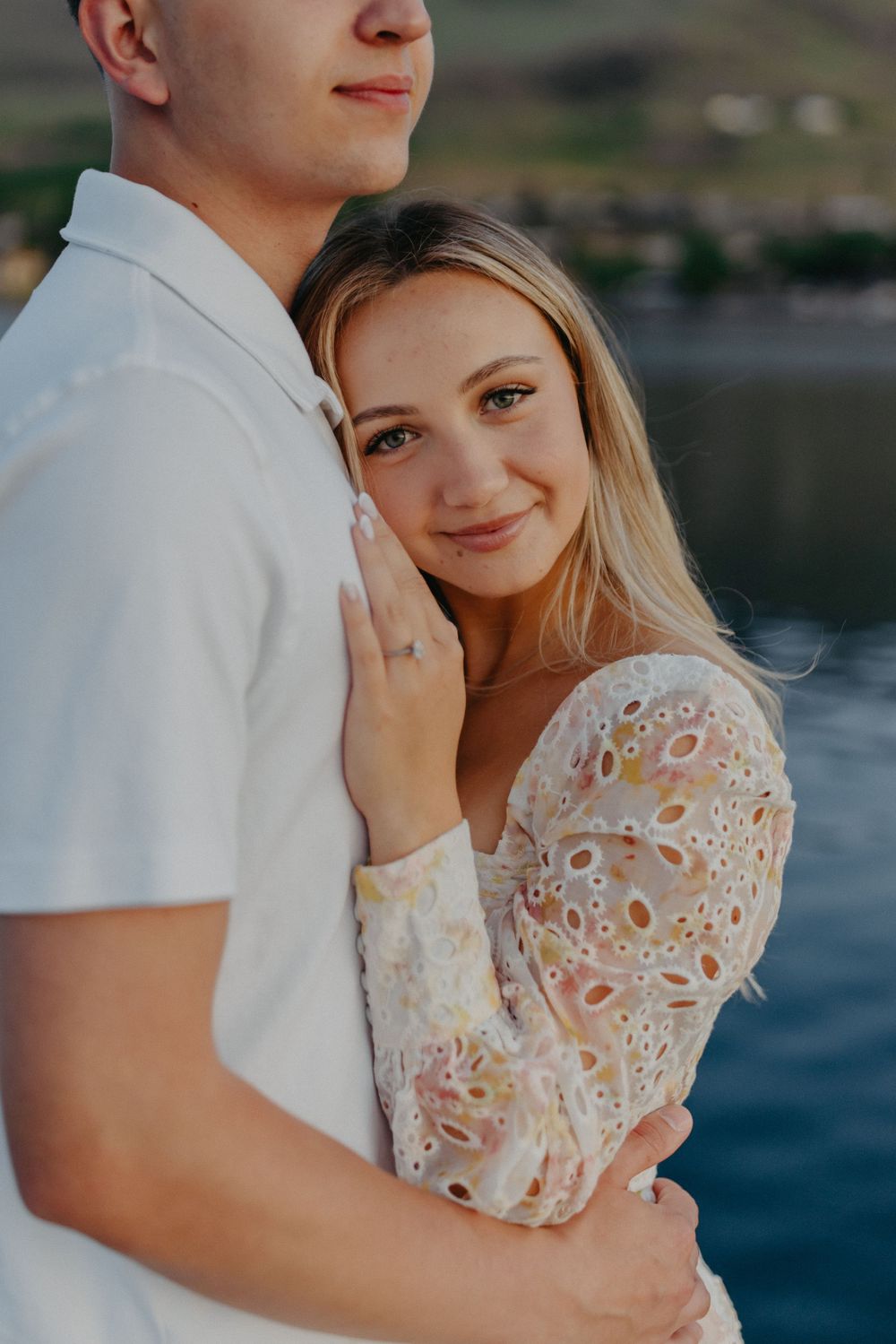 A tender romantic moment captured at a lakeside marina during sunset.