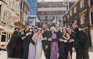 Wedding party and bride and groom squeezing together for a photo by The Lower Deck, downtown Halifax, Nova Scotia
