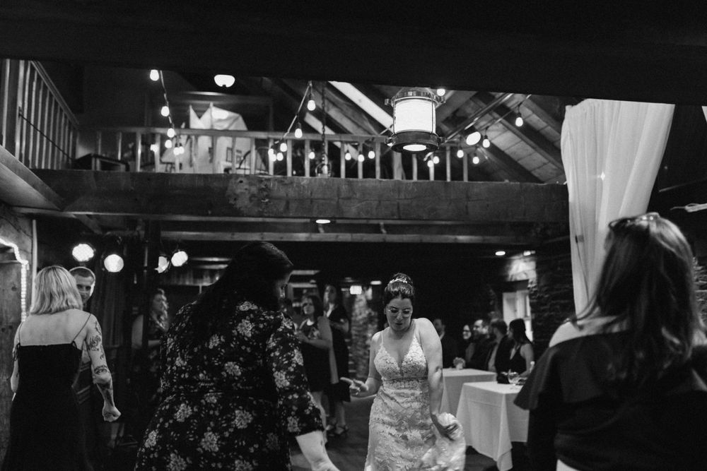 Black and white photo of bride tearing it up on the dance floor at The Lower Deck, The Tap Room in Halifax, Nova Scotia