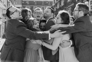 Wedding party and bride and groom squeezing together for a photo by The Lower Deck, downtown Halifax, Nova Scotia