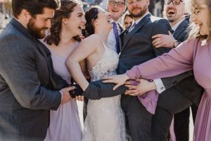 Wedding party and bride and groom squeezing together for a photo by The Lower Deck, downtown Halifax, Nova Scotia
