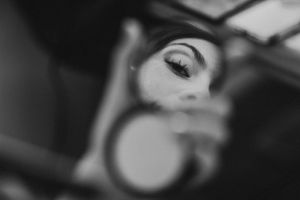 Close-up artistic shot of an eye reflecting in a mirror with blurred edges.