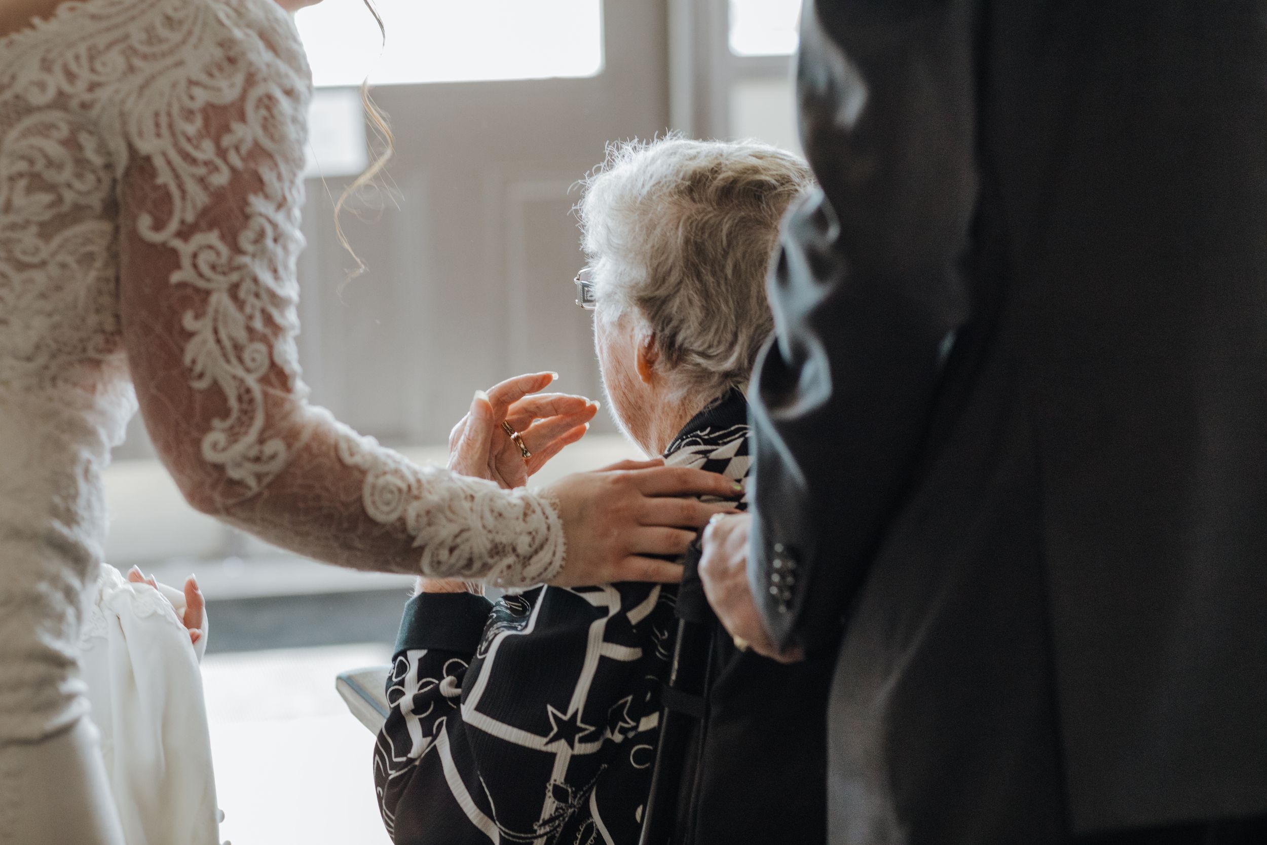 Intimate moment during wedding preparations captured in soft natural light.