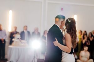 First dance moment captured at wedding reception with dramatic lighting.