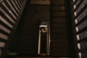 Artistic overhead view of wooden spiral staircase in dark interior setting.