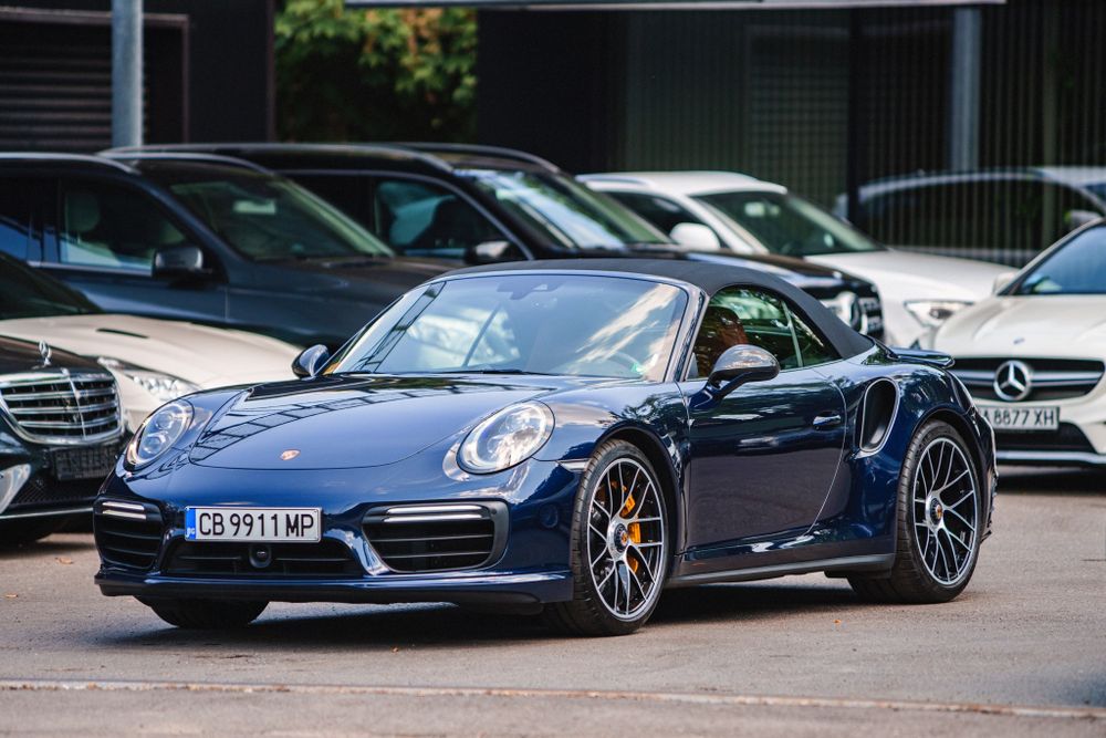 Side view of a metallic blue Porsche 911 Turbo with distinctive alloy wheels.