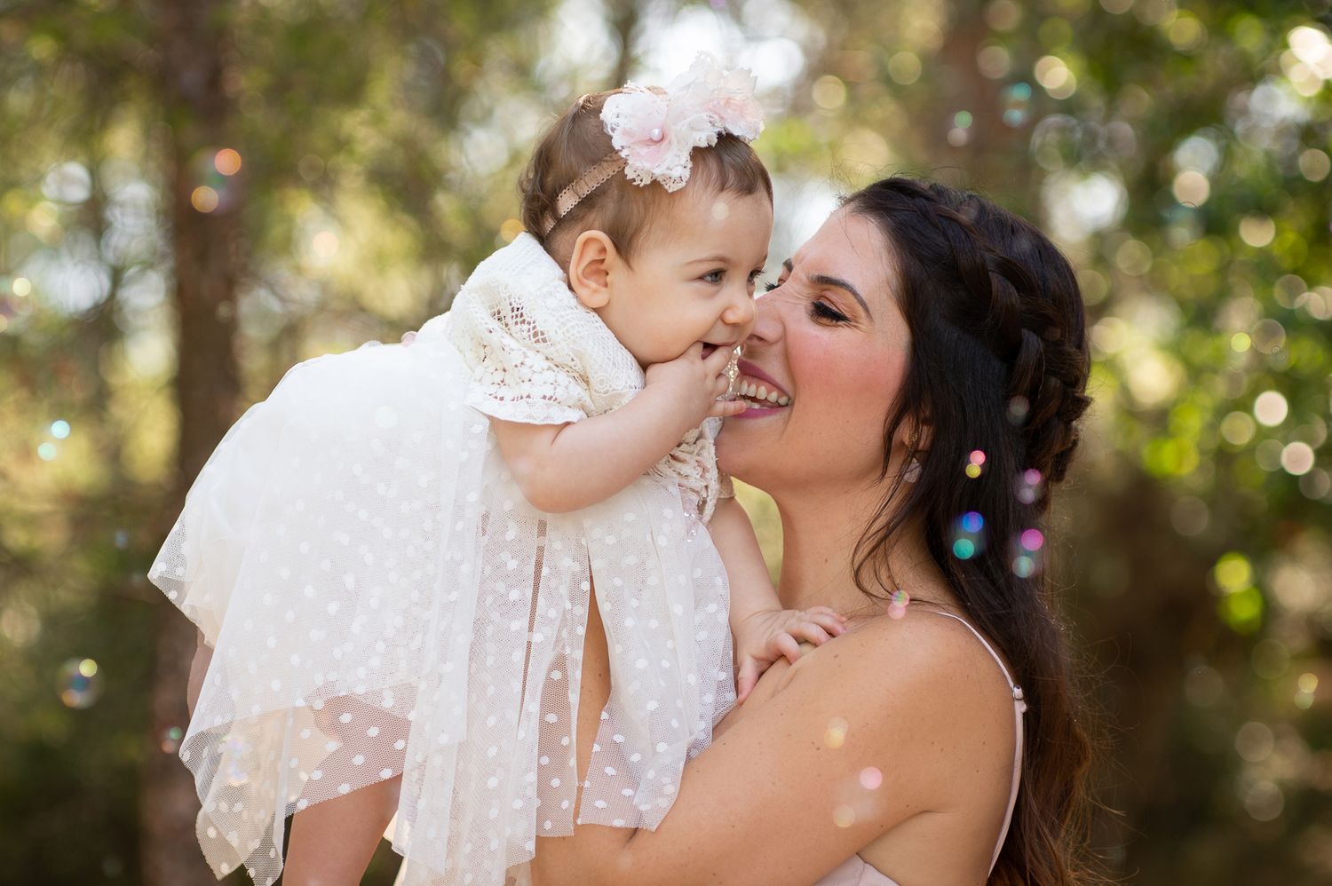 mother and baby laughing together among bubbles after the baptism