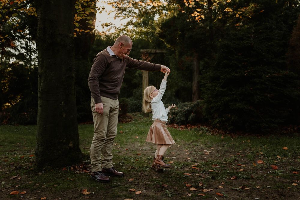 Dancing and twirling together in an autumn forest clearing at golden hour.