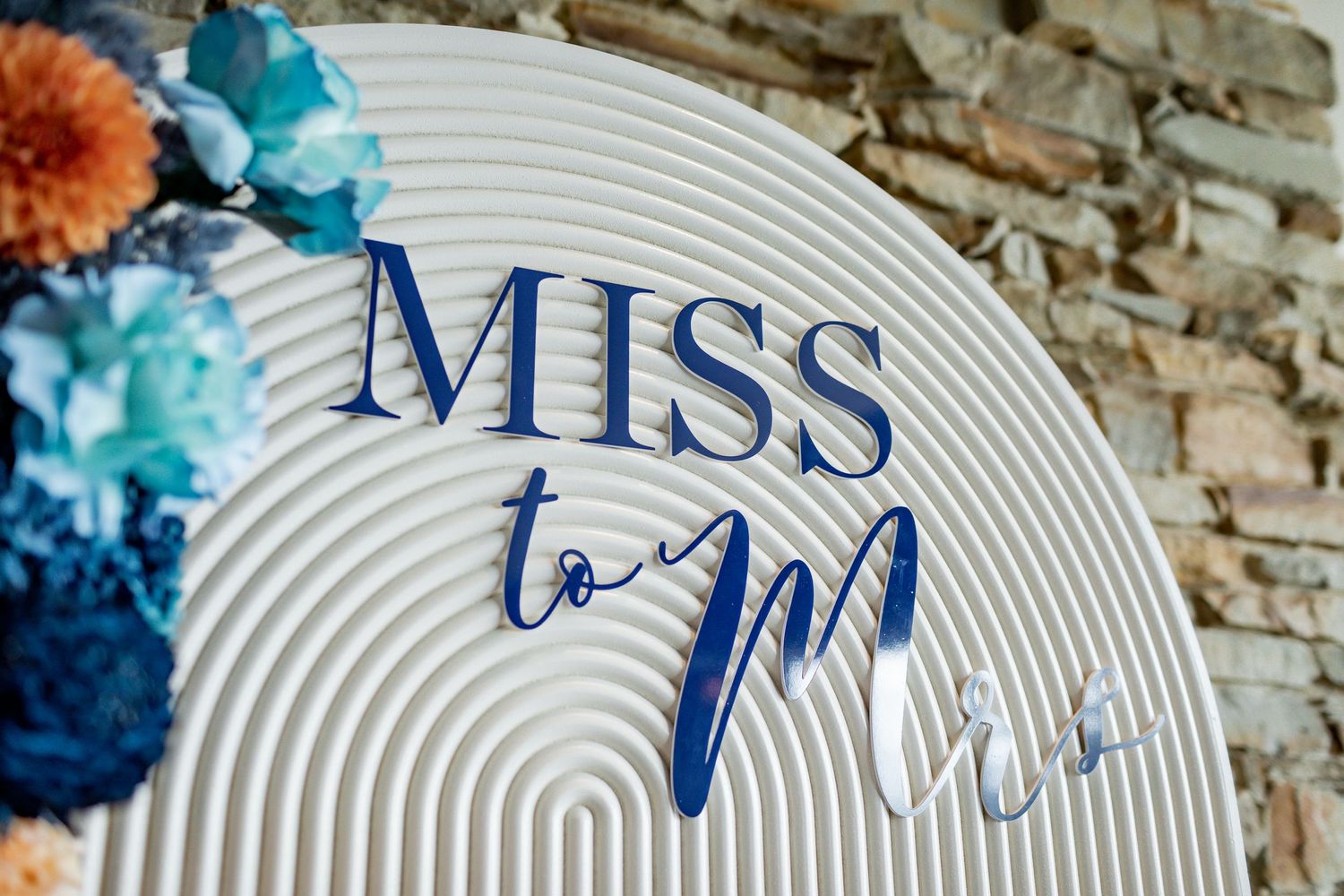 Close-up of 'Miss to Mrs' text in blue lettering on white ribbed background.