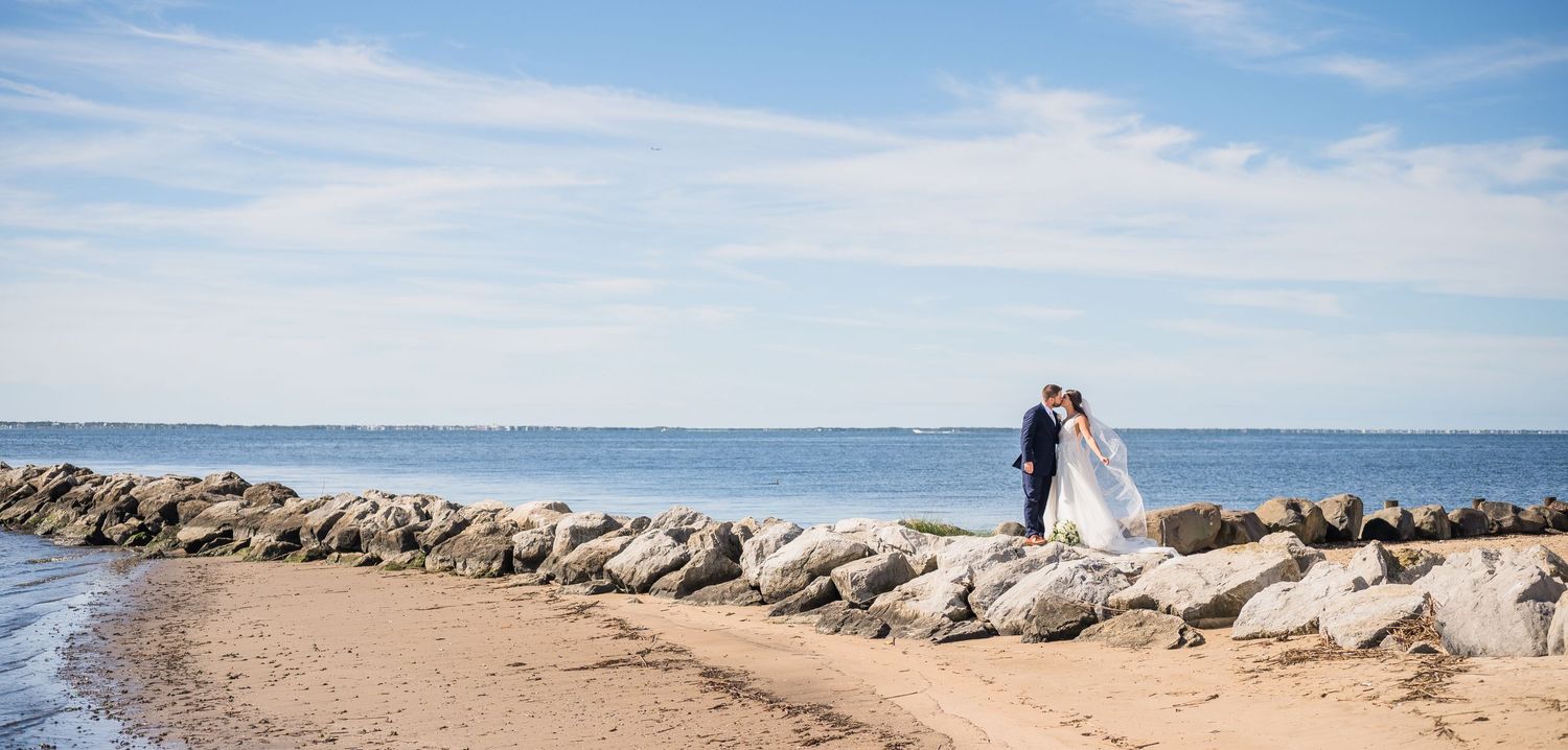 A couple shares a passionate kiss on the rocks at Lands End waterfront.