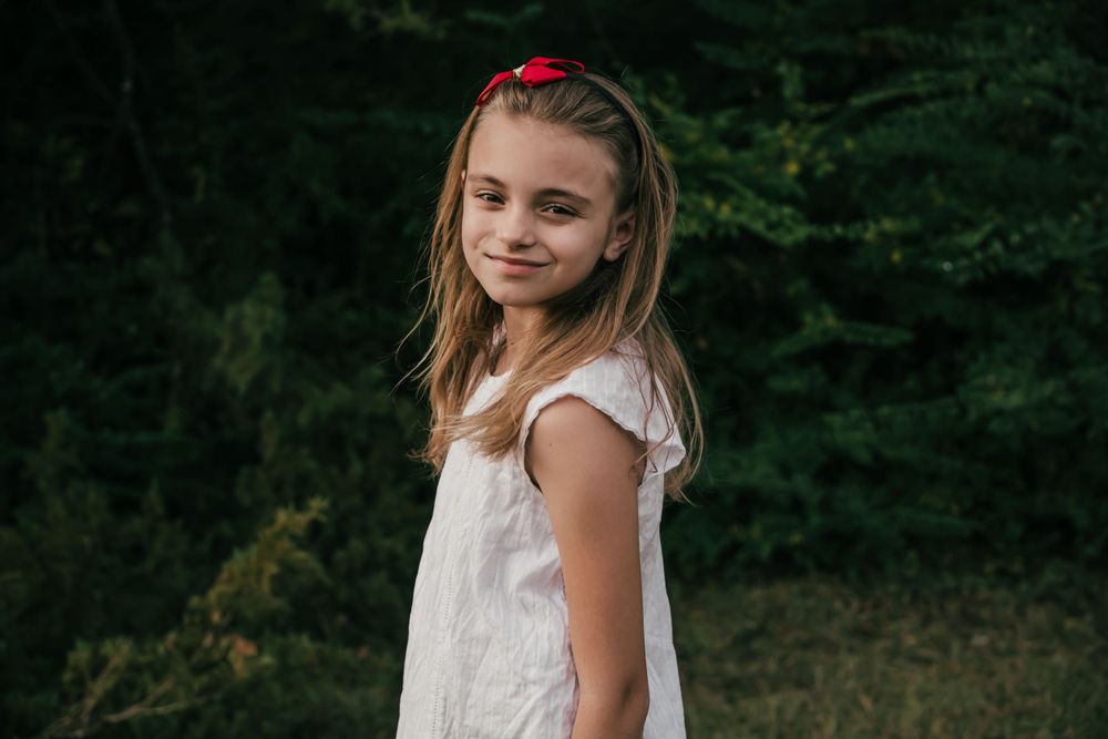 girl white shirt standing by trees