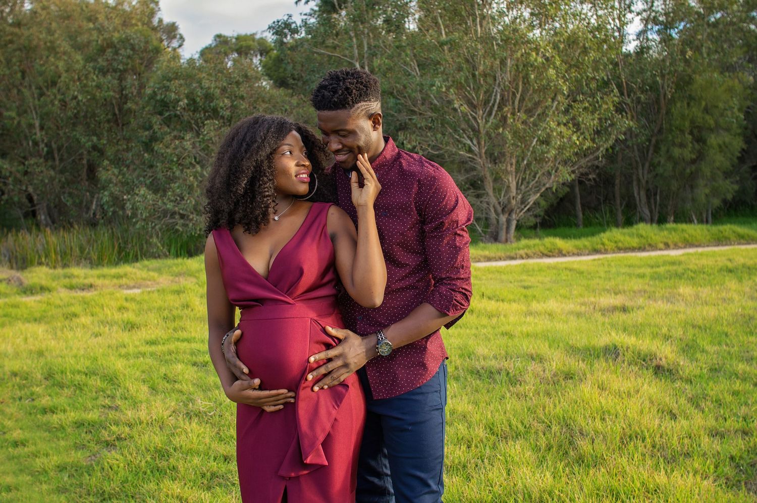 couple embracing pregnant belly outside