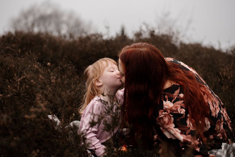 Intimate outdoor portrait showing loving moment in autumn landscape.