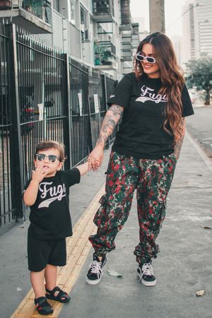 Walking together on a city sidewalk wearing coordinated outfits.