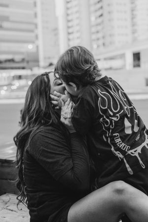 Black and white portrait of intimate moment between parent and child in matching outfits.
