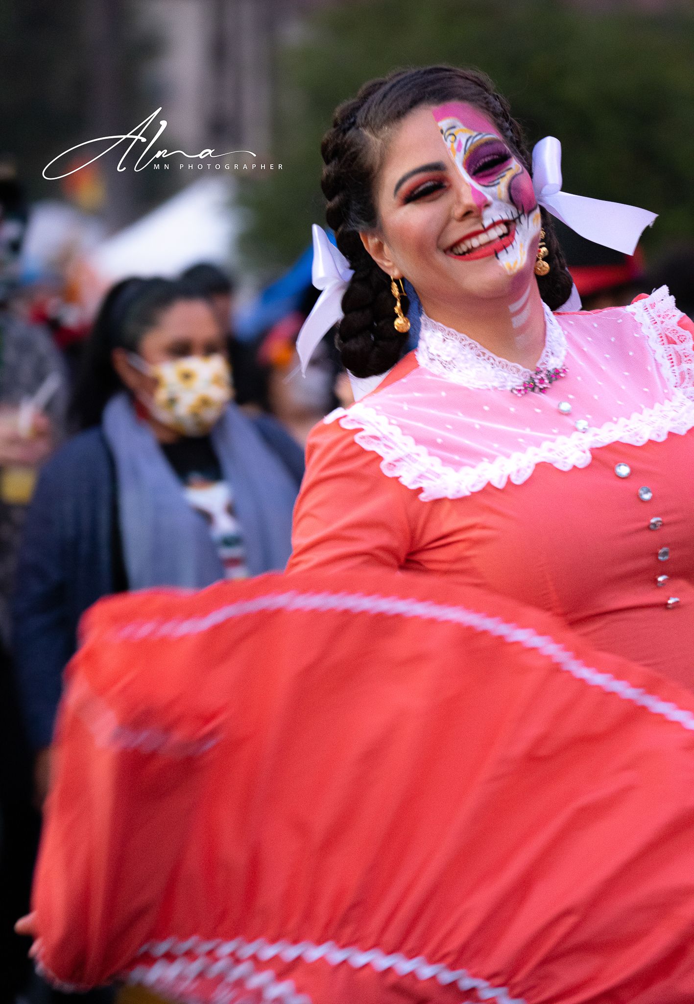 Dancer in red traditional Mexican dress twirls during cultural performance.