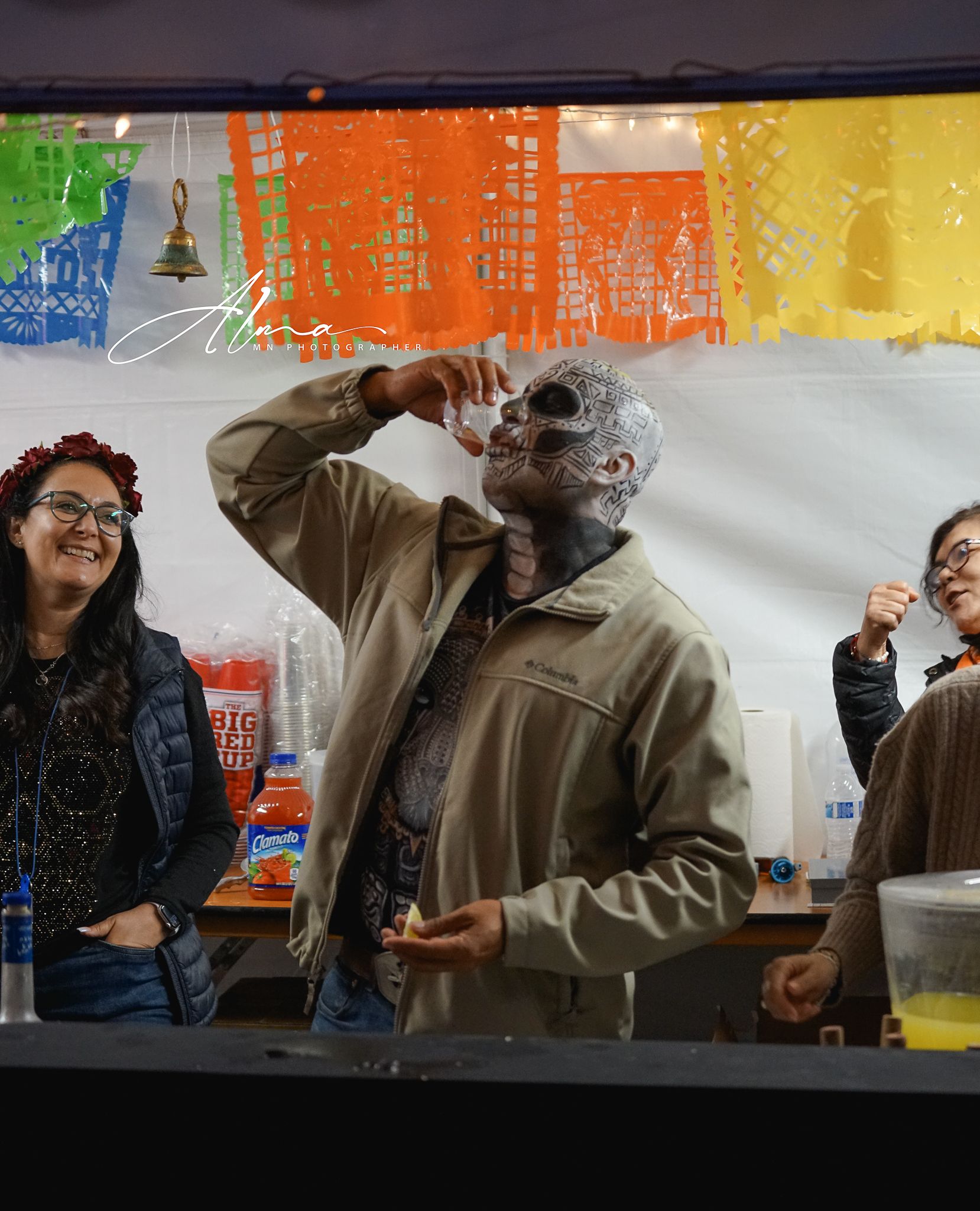 Group enjoying drinks and conversation at colorful bar setting.