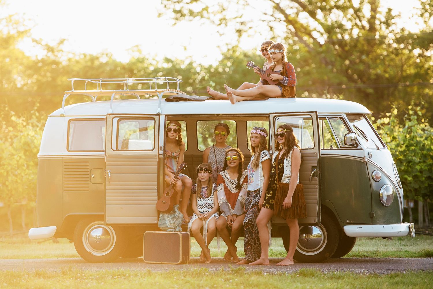 Group gathered around a vintage Volkswagen van during golden hour sunset.