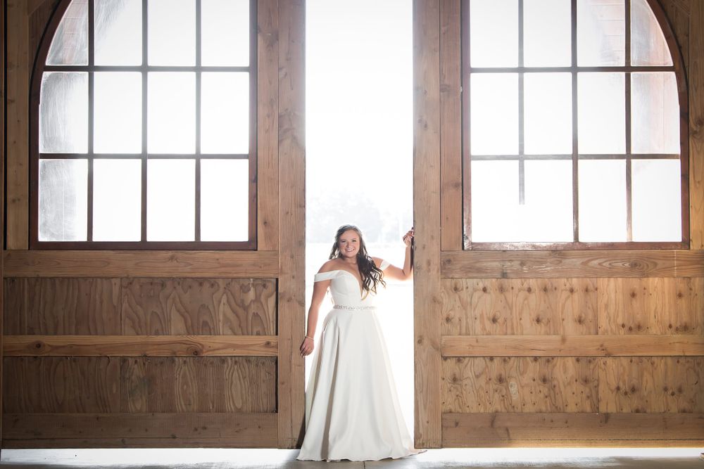 Sunlight filters through multiple paned windows in a wooden barn interior.