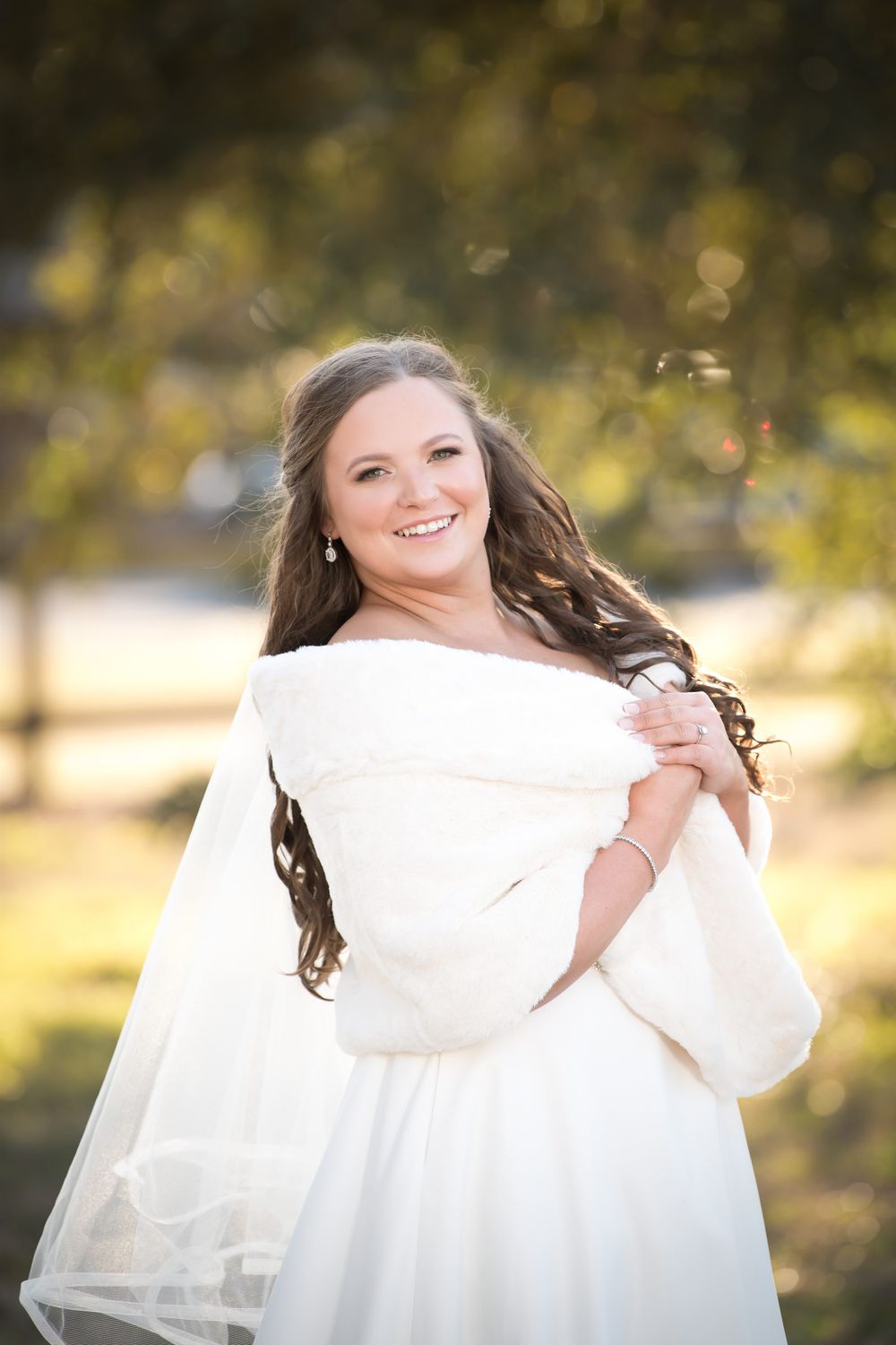 Sun-drenched bridal portraits featuring a white gown and bouquet against autumn foliage.