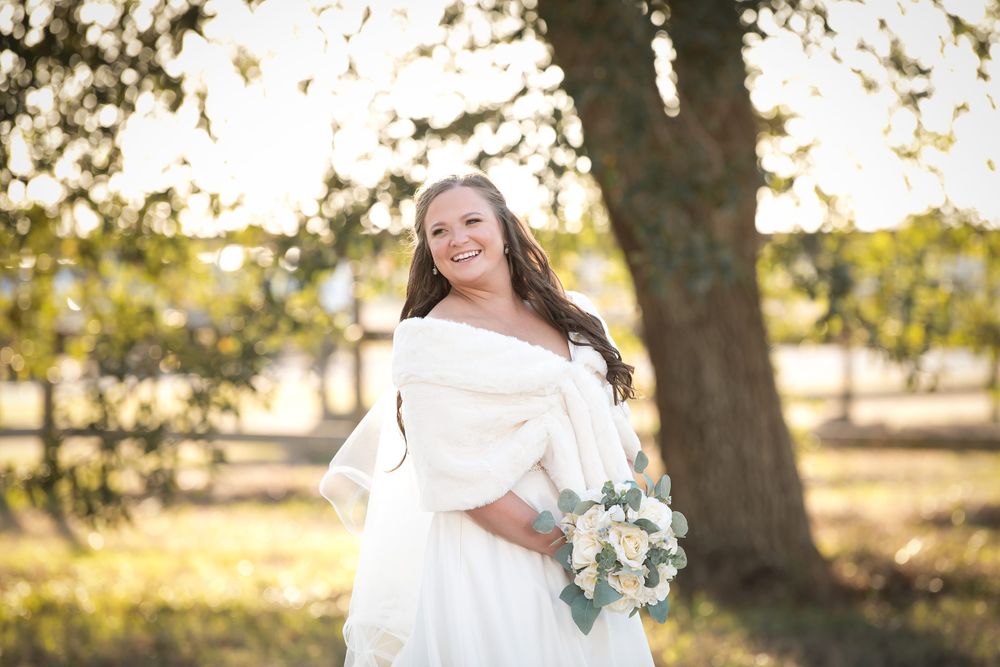 Candid bridal photography session in natural outdoor setting with soft golden lighting.