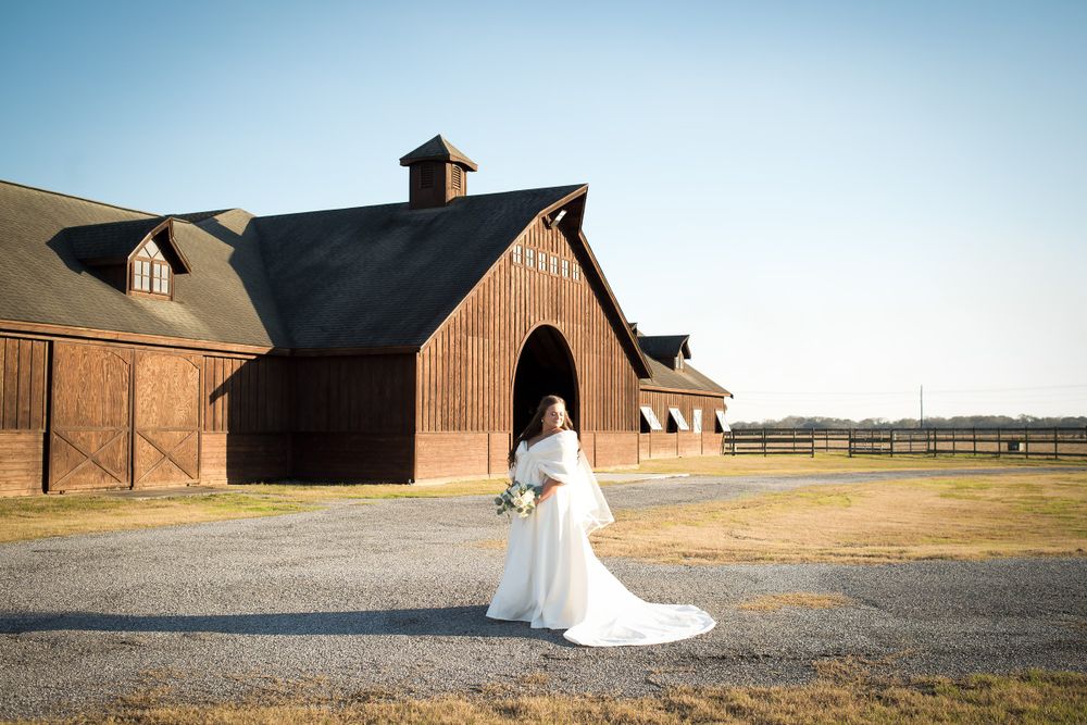 Wedding photography featuring rustic barn buildings and architectural elements in the background.