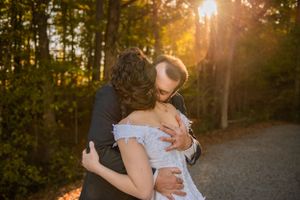 A romantic sunset photo session in a wooded area with golden light filtering through the trees.