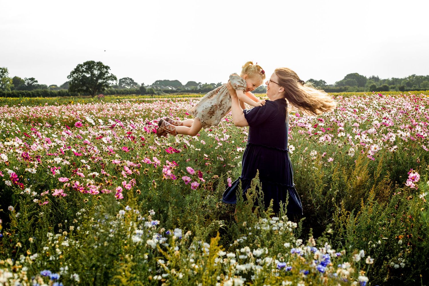 At Sam's Sunflowers on Hayling Island, Hampshire, a Mum and Daughter play in the flowers.