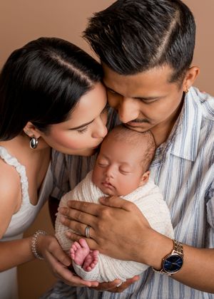 A tender moment between parents and their newborn baby captured in a series of intimate close-up photographs.