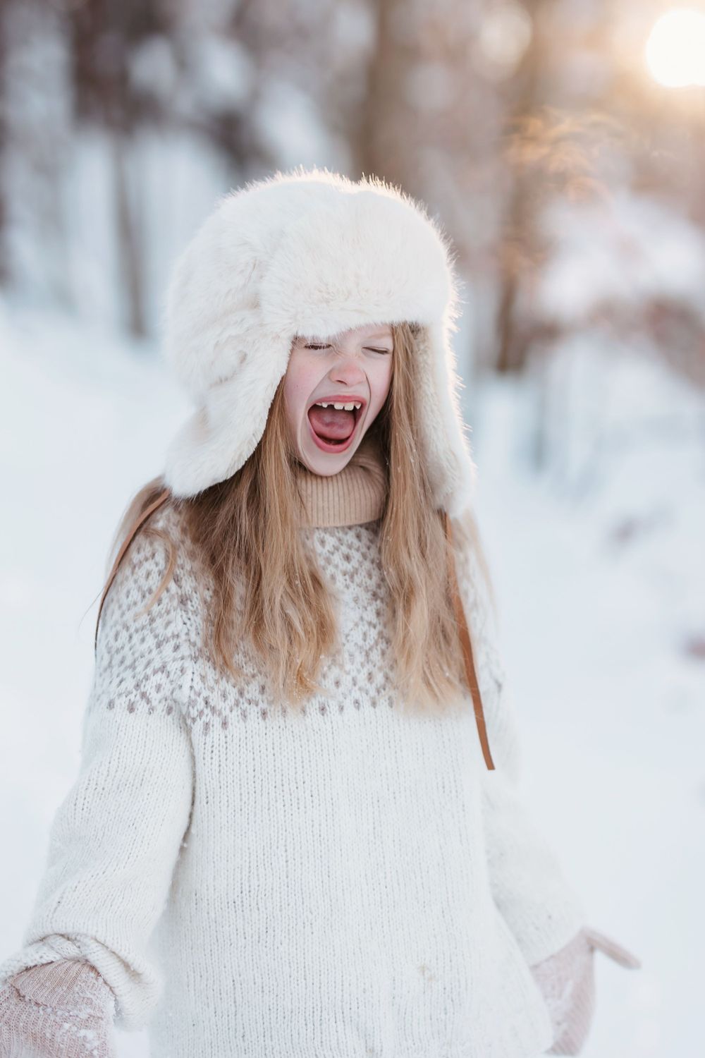 Glad jente som ler i vakkert snølandskap