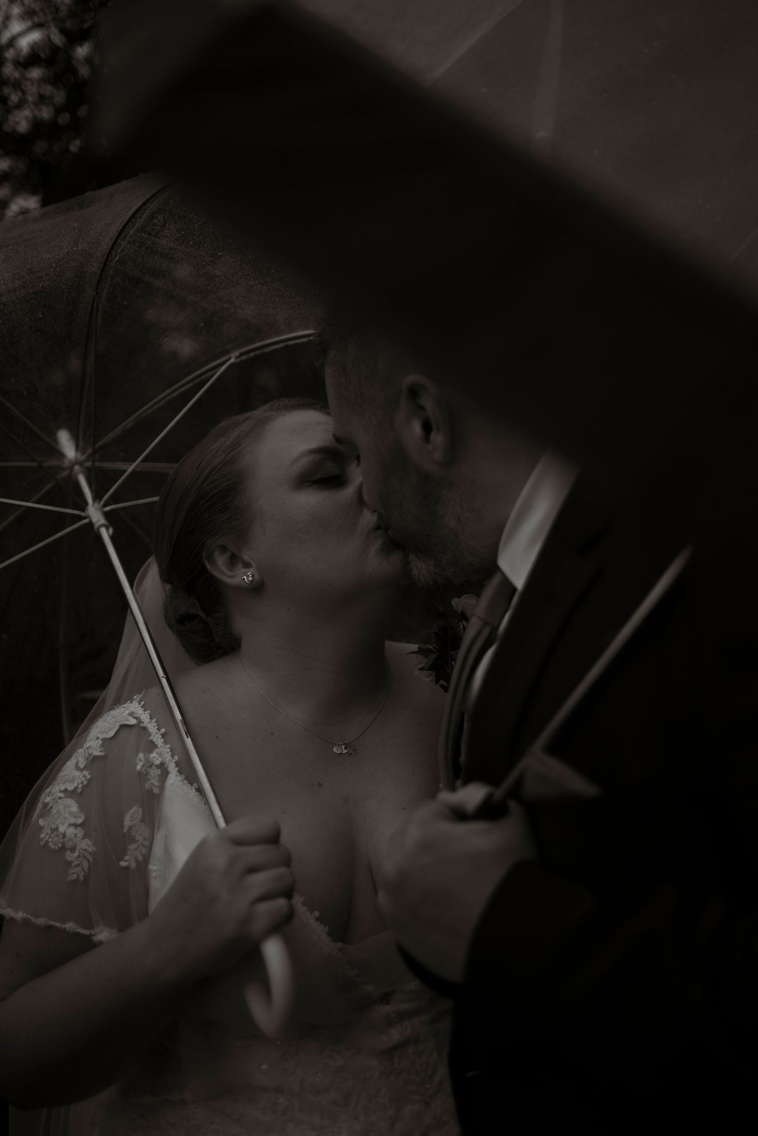 bride and groom kissing under umbrellas, sheffield wedding, rainy wedding