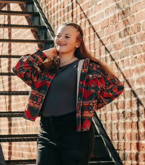 Candid fashion shots against a brick wall featuring a red patterned jacket.