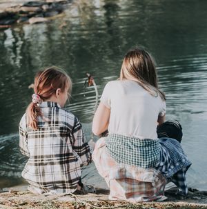 People sitting together on a lakeside bench enjoying a peaceful moment.