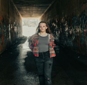 Atmospheric tunnel photoshoot with dramatic backlighting creating silhouettes.