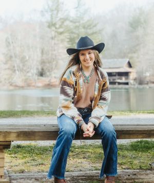 Lakeside outdoor portrait session with rustic wooden deck and natural scenery.